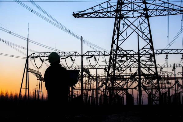 Electricity workers and pylon silhouette