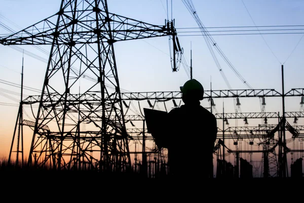 Trabajadores de la electricidad y silueta de pilón — Foto de Stock