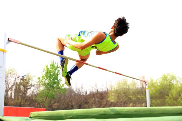 A male athlete is on the high jump — Stock Photo, Image