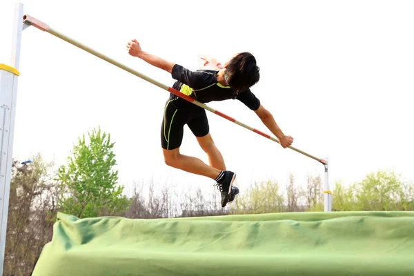 Un atleta masculino está en el salto alto — Foto de Stock