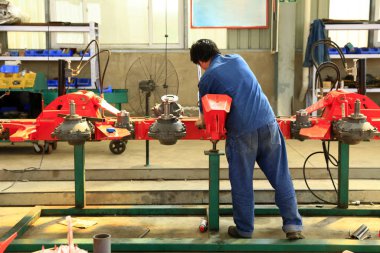 İşçiler fabrikanın atölyesinde çalışıyor.,