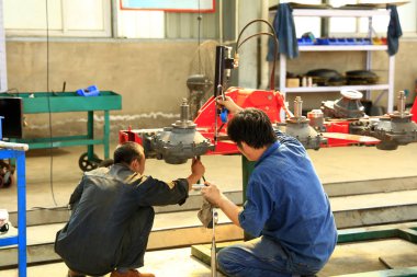 İşçiler fabrikanın atölyesinde çalışıyor.,