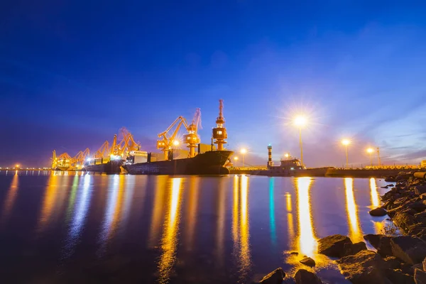 Grúa pórtico y buque de carga por la noche — Foto de Stock