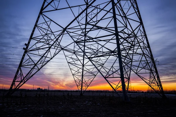 A silhueta do pilão de transmissão de eletricidade à noite — Fotografia de Stock