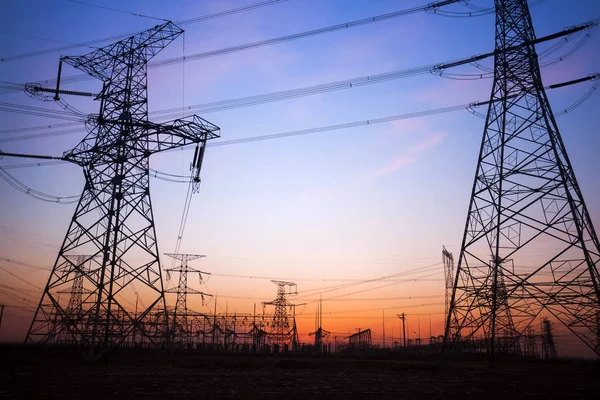 A silhueta do pilão de transmissão de eletricidade à noite — Fotografia de Stock