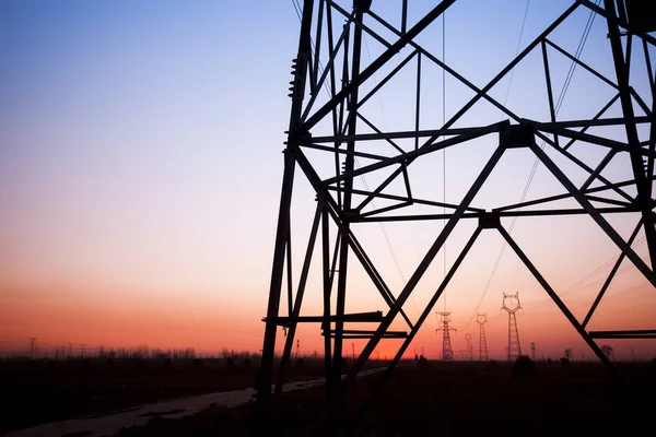 A silhueta do pilão de transmissão de eletricidade à noite — Fotografia de Stock