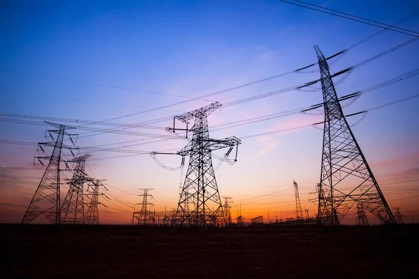 A silhueta do pilão de transmissão de eletricidade à noite — Fotografia de Stock