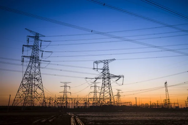 A silhueta do pilão de transmissão de eletricidade à noite — Fotografia de Stock