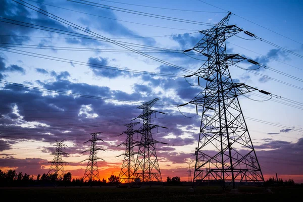 A silhueta do pilão de transmissão de eletricidade à noite — Fotografia de Stock