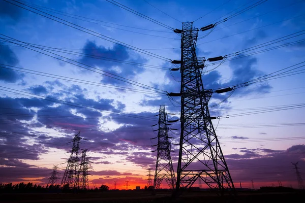 Het silhouet van de avond hoogspanningsmast transmissie — Stockfoto