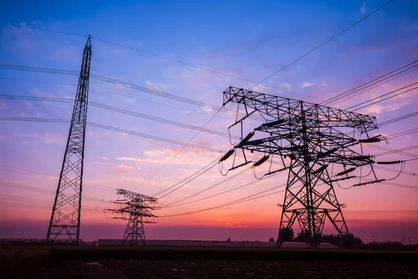 A silhueta do pilão de transmissão de eletricidade à noite — Fotografia de Stock