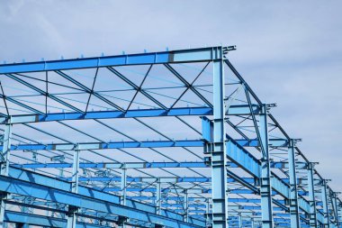 Çelik iskelet yapısı mavi gökyüzünün altında.
