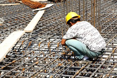 İnşaat alanında beton döşeme için takviye metal iskeleti yapan işçiler