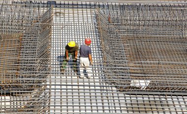 İnşaat alanında beton döşeme için takviye metal iskeleti yapan işçiler