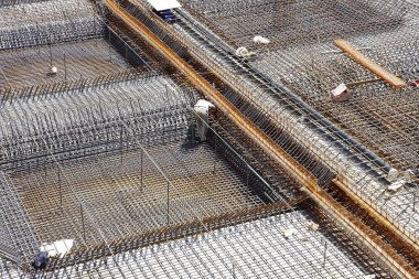 İnşaat alanında beton döşeme için takviye metal iskeleti yapan işçiler