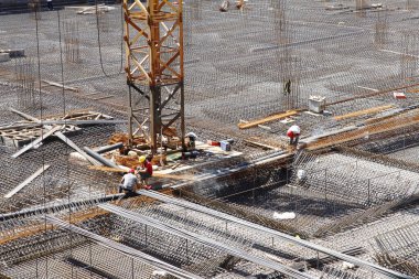 İnşaat alanında beton döşeme için takviye metal iskeleti yapan işçiler