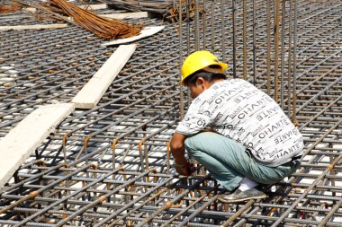 İnşaat alanında beton döşeme için takviye metal iskeleti yapan işçiler