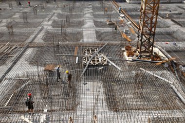 İnşaat alanında beton döşeme için takviye metal iskeleti yapan işçiler