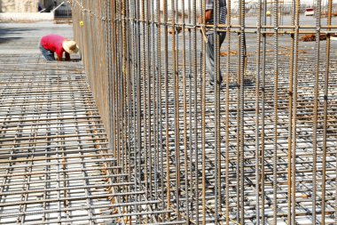 İnşaat alanında beton döşeme için takviye metal iskeleti yapan işçiler