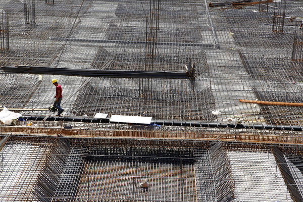 worker in the construction site making reinforcement metal framework for concrete pouring
