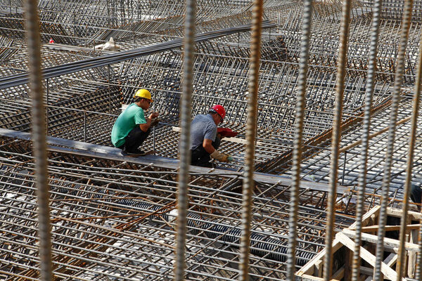 worker in the construction site making reinforcement metal framework for concrete pouring