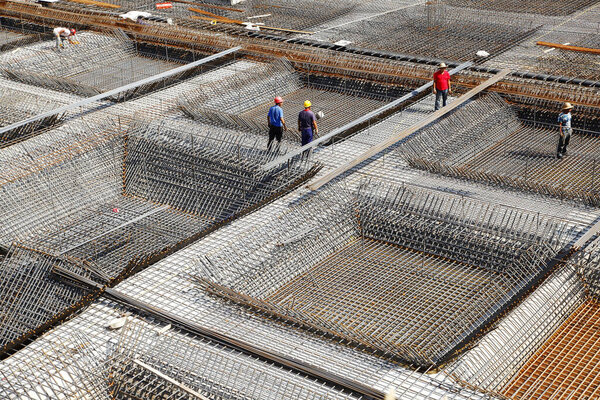 worker in the construction site making reinforcement metal framework for concrete pouring