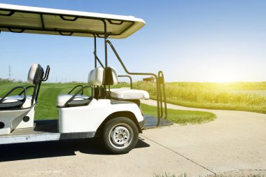 Yeşil golf sahasında beyaz golf arabaları.