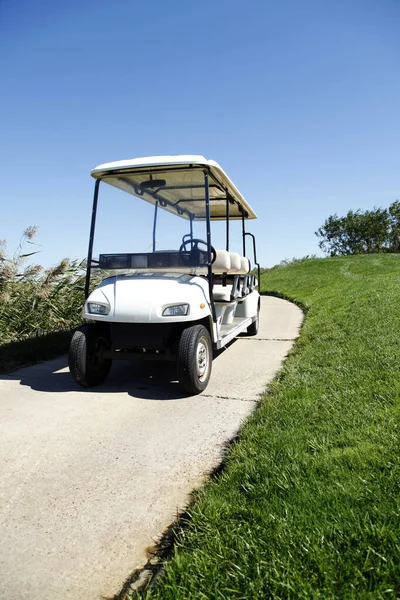 绿色高尔夫球场的白色高尔夫球车 — 图库照片