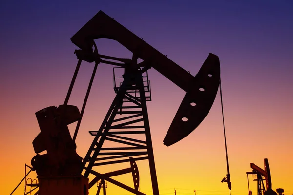 Oil field scene, the evening of beam pumping unit in silhouette