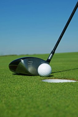 Golf sopası ve top çimenlerde.