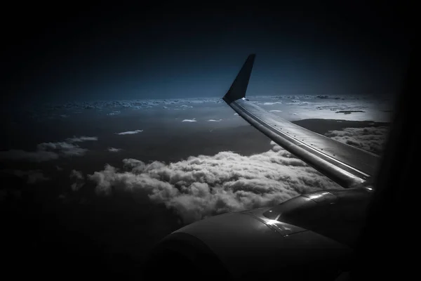 Vue depuis la fenêtre d'un avion pendant le coucher ou le lever du soleil. Aile d'un avion volant au-dessus du fond des nuages — Photo