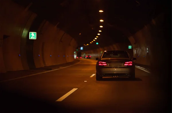 car driving through tunnel; highway tunnel at night