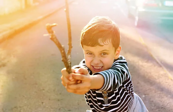 Cute young boy playing on the street with wooden stick and standing in fighting pose .Fight demonstration. — Stock Photo, Image