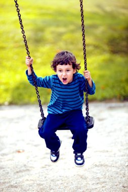 Sevimli çocuk 5-6 yaş salıncakta sallanan portresi. Etkin boş çocuklarla. Mutlu çocuk.