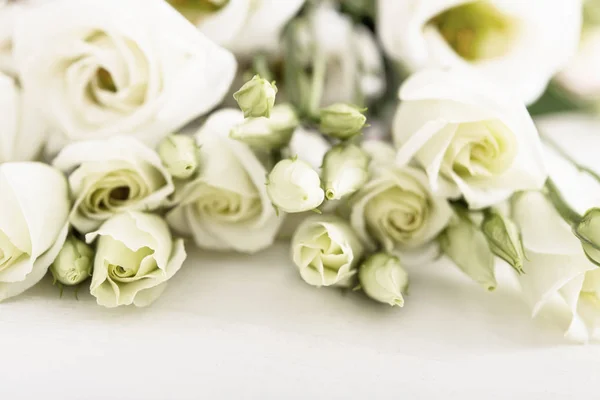 Strauß weißer Rosen auf weißem Holztisch — Stockfoto