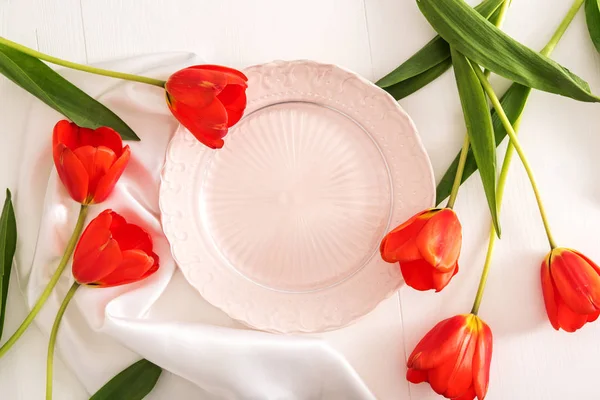 Empty plate and red tulips — Stock Photo, Image
