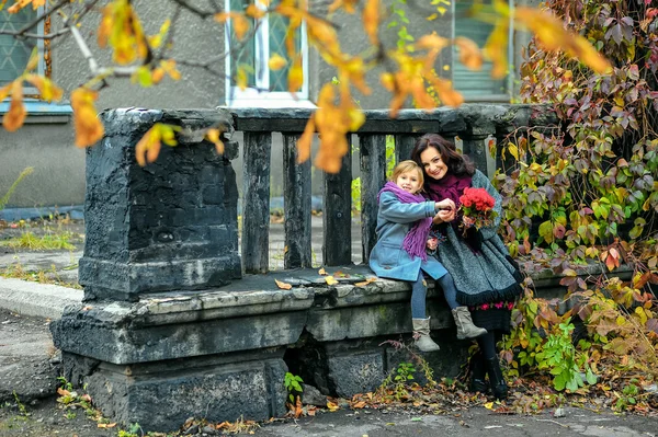 Mãe com um rosto surpreso brincando com uma filha no outono — Fotografia de Stock