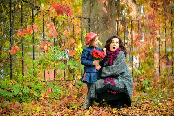 mother with a surprised face fooling around with a daughter in autumn