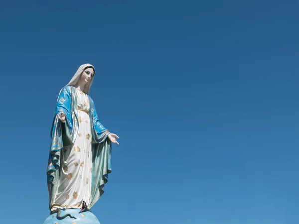 Jungfrau Maria Statue auf blauem Himmel Hintergrund — Stockfoto