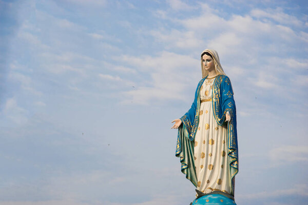 Virgin mary statue with blue sky background