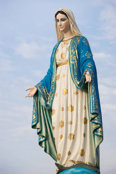 Virgin mary statue with blue sky background