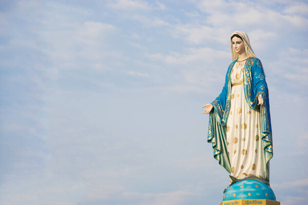 Virgin mary statue with blue sky background
