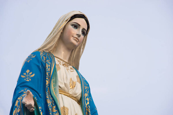 Virgin mary statue blue sky background