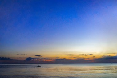 Sahilde gün batımında tekne.