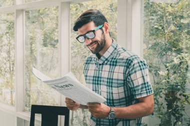Genç iş adamı sabahları iş haberleri okuyor.