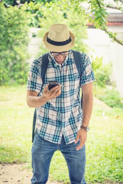 Sırt çantasını taşıyan gözlüklü mutlu genç sakallı adam.