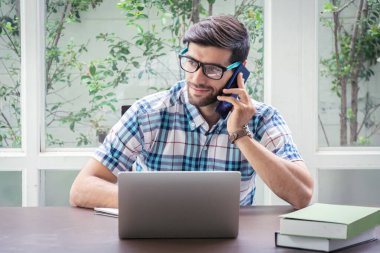 Genç Kafkasyalı işadamı ev ofisinde dizüstü bilgisayarla çalışıyor.