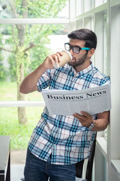 Young casual businessman reading business news in the morning at