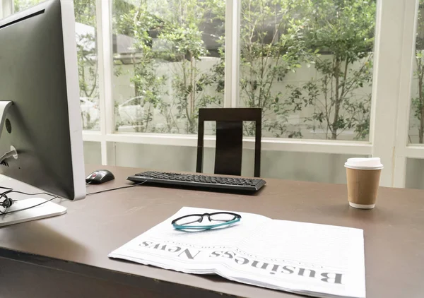 호호에 있는 컴퓨터 책상에 커피가 담긴 비즈니스 신문 — 스톡 사진