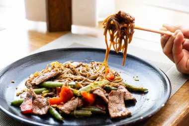 Siyah tabakta ızgara etli Çin eriştesi. Boşluğu kopyala